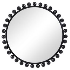 a round mirror with black balls around it