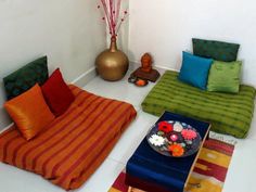 a living room filled with lots of colorful pillows and blankets on top of each other