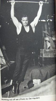 the man is holding up his barbells in an old black and white photo