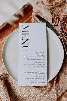 a white plate with a menu sitting on top of it next to a fork and knife