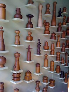 a wall full of wooden chess pieces on shelves