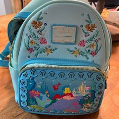 Loungefly - Disney Princess Stories Series The Little Mermaid Ariel Backpack Rare! Hard To Find! Never Used, No Tags Light Blue 10 X 4 X 8 Adjustable Straps Embroidered On Front And Back , Leather Shell Cut Out Trim Inside Zipper Pocket 2 Side Pocket Slips Front Zipper Pocket For Phone Etc. Smoke Free Home Thanks! Ariel Backpack, Disney Princess Stories, Mermaid Backpack, Loungefly Backpack, Princess Stories, The Little Mermaid Ariel, Family Disney Trip, Little Mermaid Ariel