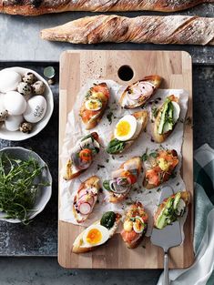 a wooden cutting board topped with lots of different types of food on top of it