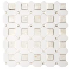 a white tile wall with square and hexagonal tiles on the bottom, in different sizes