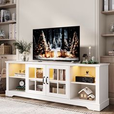 a flat screen tv sitting on top of a white entertainment center in a living room