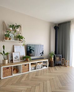 a living room filled with furniture and a flat screen tv on top of a wooden shelf