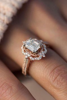 a woman's hand with an engagement ring on it and the diamond in the center