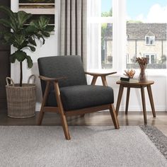 a blue chair sitting in front of a window next to a table with a potted plant