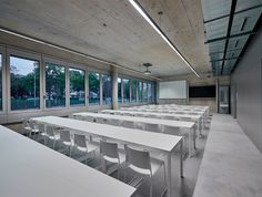 an empty room with white tables and chairs