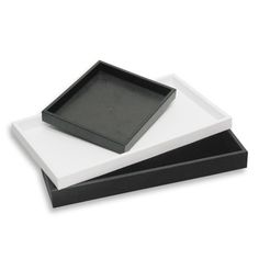 two black and white square trays sitting on top of each other in front of a white background