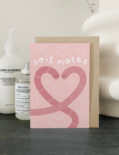 a card with two hearts and the words soil mates on it next to some hand sanitizers