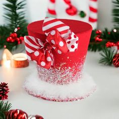 a red hat with white and red bows on it sitting in front of christmas decorations