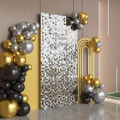 an entrance decorated with gold, silver and black balloons for a new year's eve party