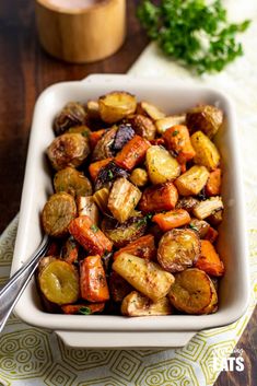 a white bowl filled with roasted vegetables on top of a table