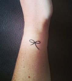 a person with a small tattoo on their left arm that has a cross in the middle