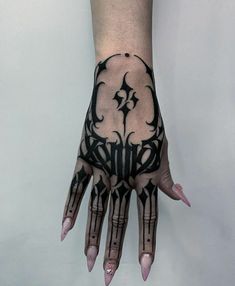 a person's hand with black and white tattoos on it, showing the design