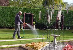 a man is watering the lawn with a hose