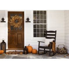 a front porch with rocking chairs and pumpkins