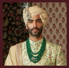 a man wearing a turban and green beads