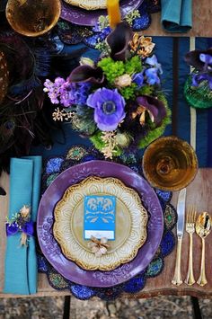 the table is set with purple and gold plates