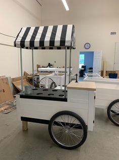 an ice cream cart in a warehouse with boxes on the floor and other items behind it