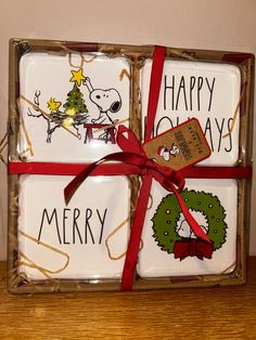 three square glass coasters decorated with christmas images and red ribbon tied around the edges