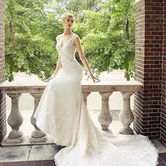 a woman in a wedding dress standing on a balcony