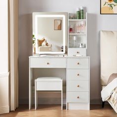 a bedroom with a white dresser and mirror next to a bed in front of a window