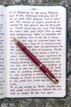 a fountain pen sitting on top of an open notebook