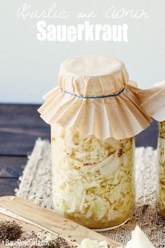 two jars filled with sauerkraut sitting on top of a table