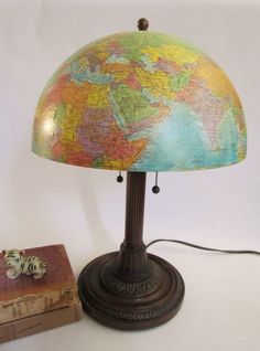 a lamp that is sitting on top of a table next to a book and a clock