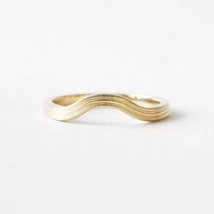 a gold wave ring on a white background