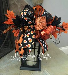 a lantern decorated with pumpkins and leaves