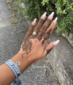 a woman's hand with henna tattoos on it