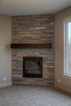 an empty room with a fireplace and window