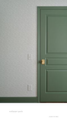 an empty room with a green door and wallpaper