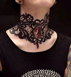 a woman with tattoos on her neck wearing a black lace choker and matching earrings