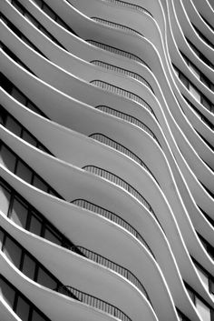 black and white photograph of an architectural building with curved balconies on the side