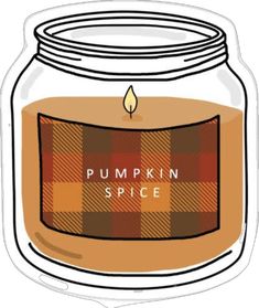 a glass jar filled with pumpkin spice sitting on top of a white table next to a candle