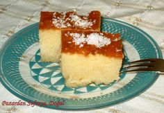 two pieces of cake on a blue plate with a fork and white lace tablecloth