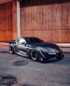 a gray sports car parked in front of a garage