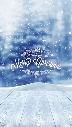 a snowy scene with the words merry christmas written in white letters on blue and green background