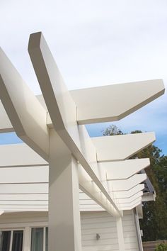 a close up of a white structure on the side of a building with trees in the background