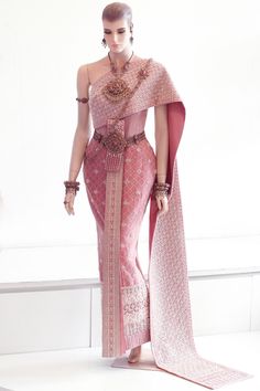 a woman in a pink sari is walking down the runway with her hand on her hip