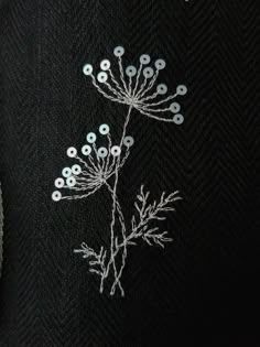 a black jacket with white flowers embroidered on it