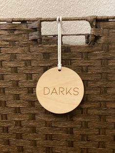 a wooden sign that says darks hanging from a wicker basket on the wall