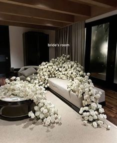 a living room with white flowers on the floor and couches in front of it