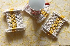 three crocheted coasters sitting on top of a yellow and white tablecloth