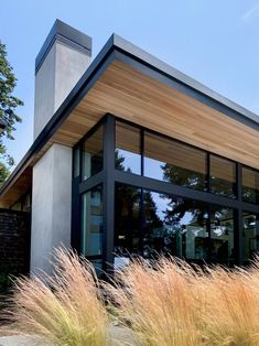 a modern house with tall grass in front of it