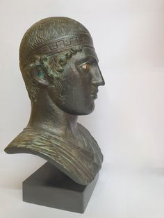 a bronze busturine of a man wearing a headdress